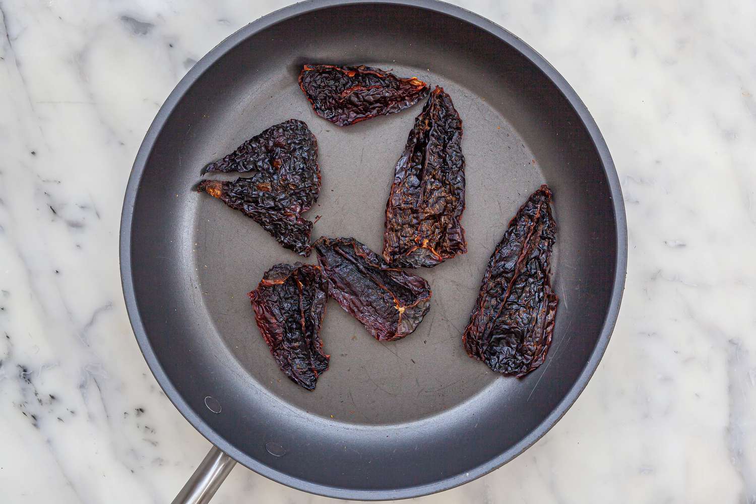 A skillet with red chilli inside.
