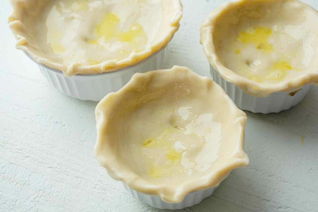 Egg wash over pastry dough for mini leftover turkey pot pies