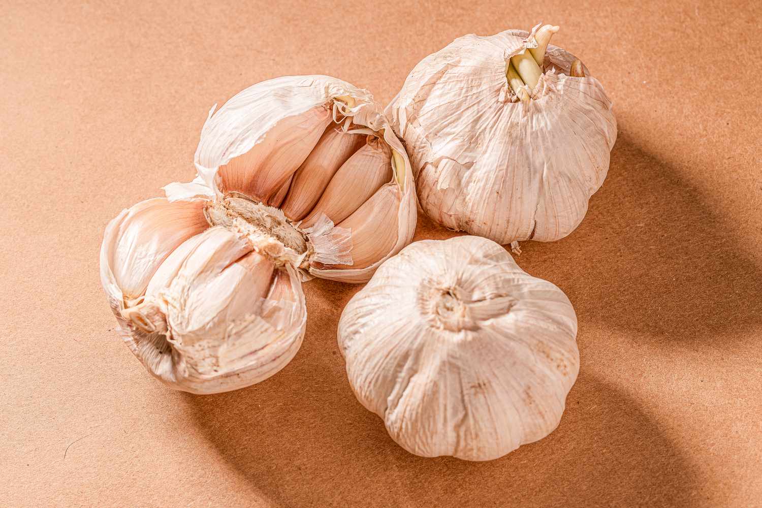 Garlic heads—including one broken open to show the cloves inside