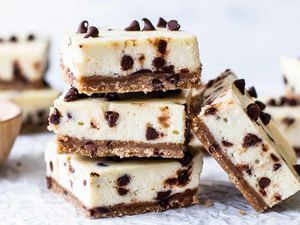 Chocolate chip cheesecake bars stacked up in a small pile