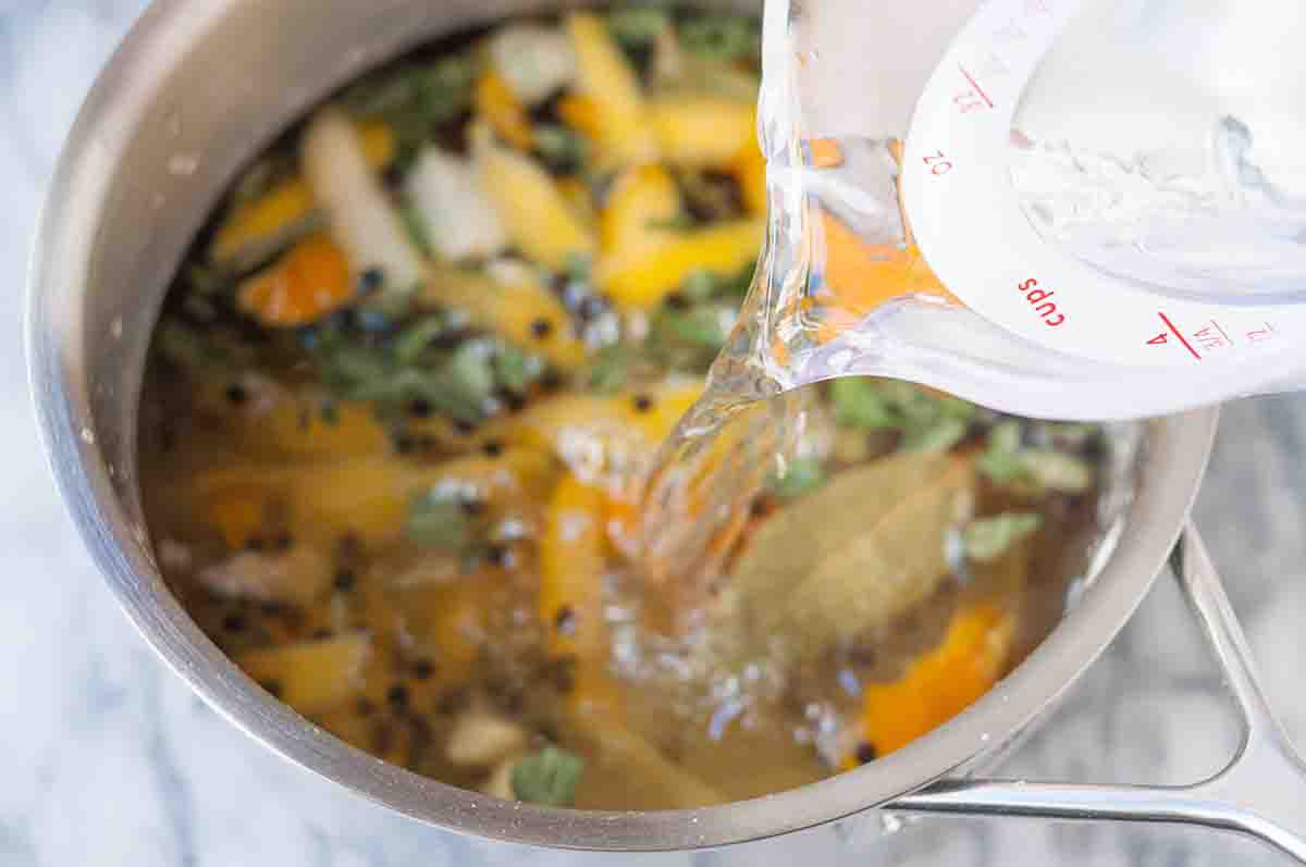 Water being poured into a pot of turkey brine