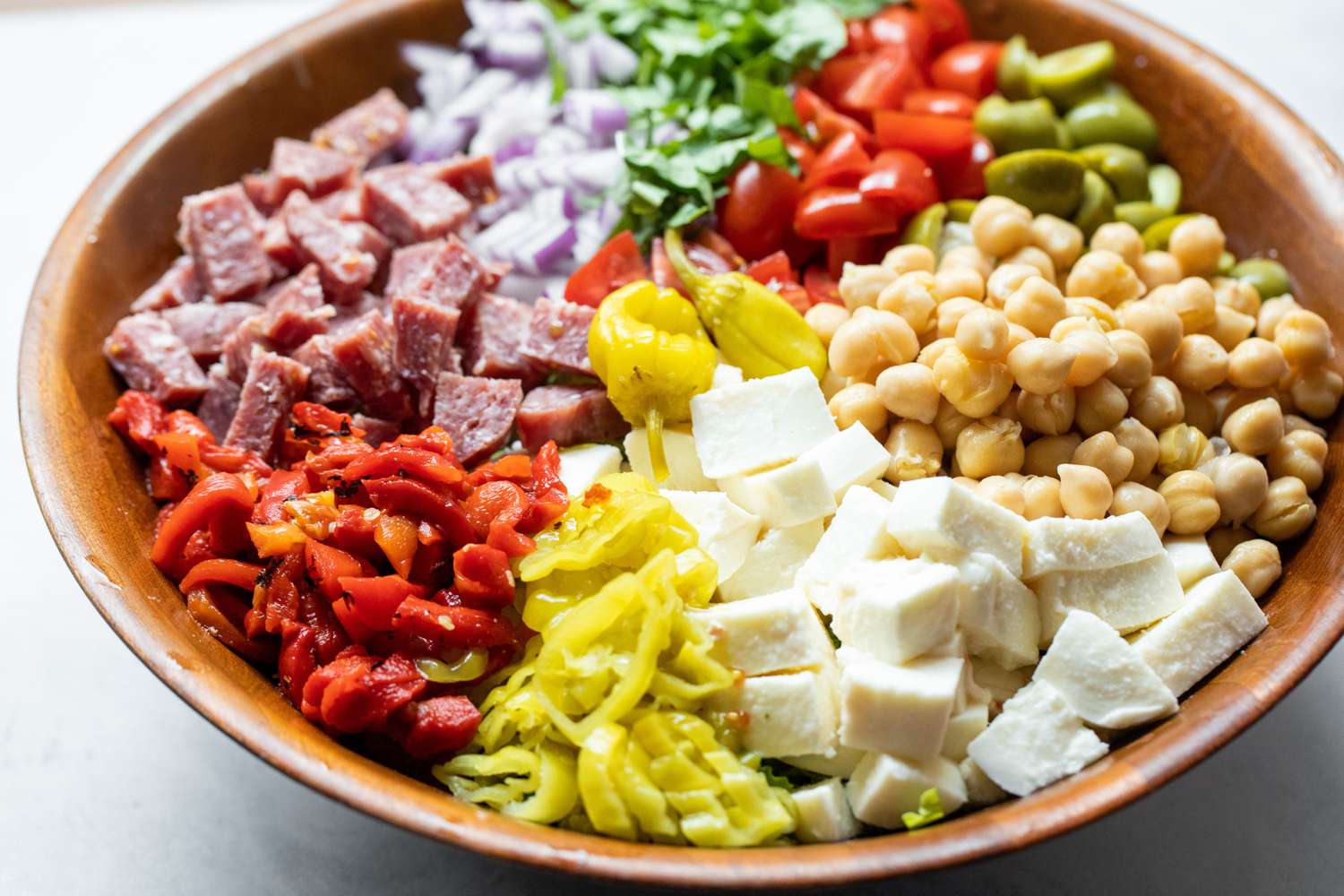 Large Bowl of Cheese, Peppers, Salami, Olives, Chickpeas, and Lettuce for Italian Chopped Salad 