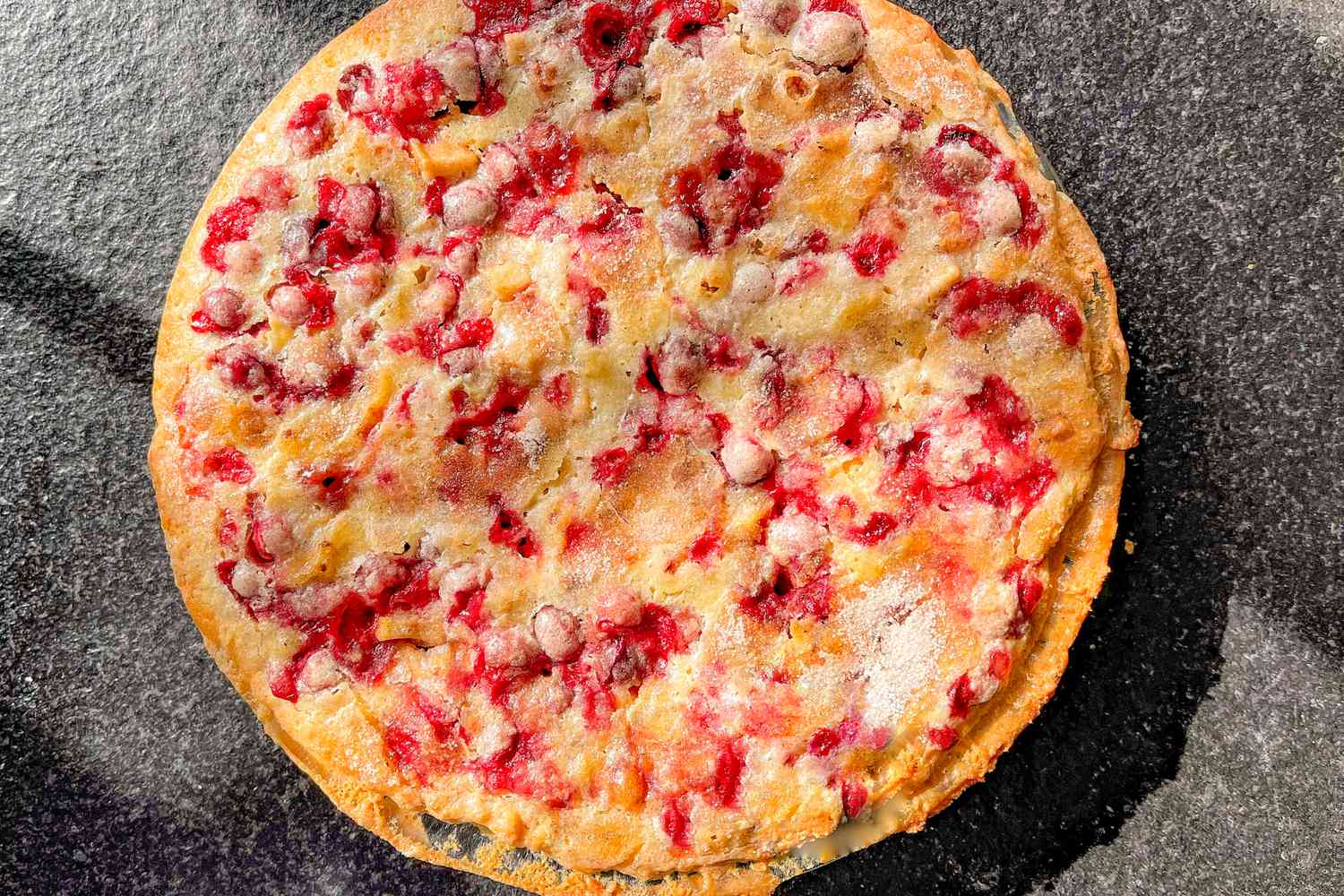 A cake studded with cranberries—the cranberries bleed into the cake, giving it beautiful red splotches