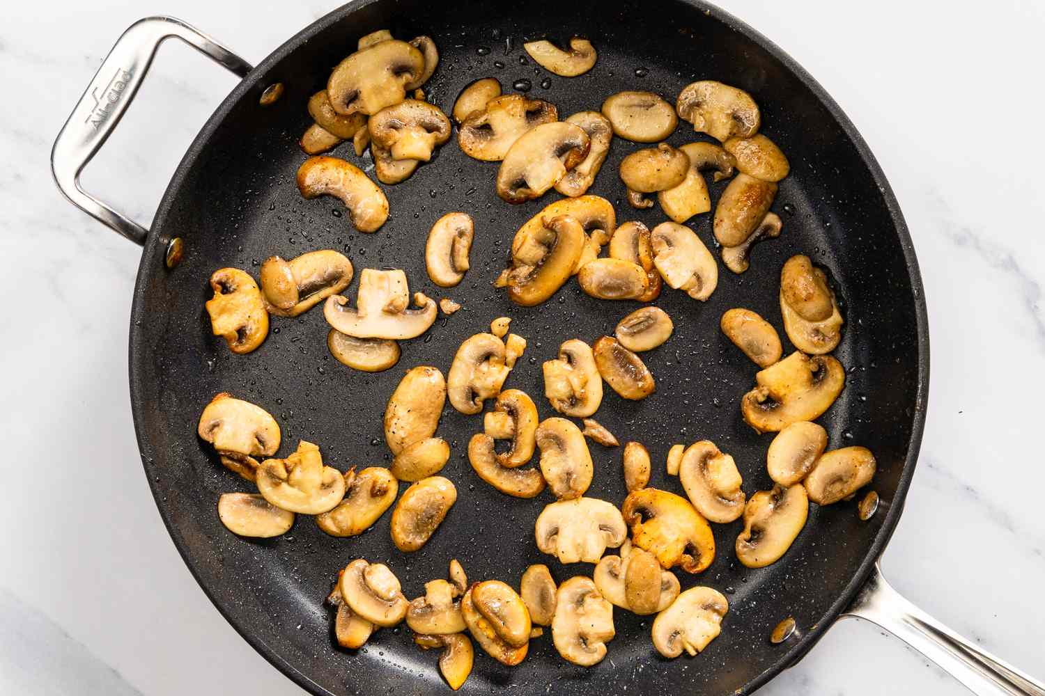 sliced mushrooms browning in a large skillet for Church Chicken Casserole recipe 