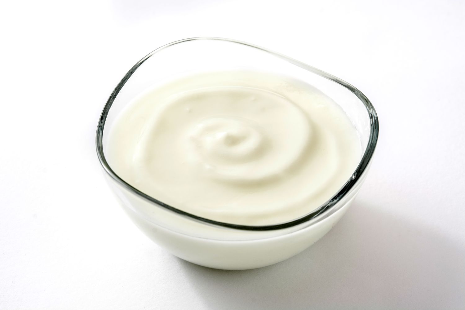 Yogurt in a clear glass bowl isolated on a white background