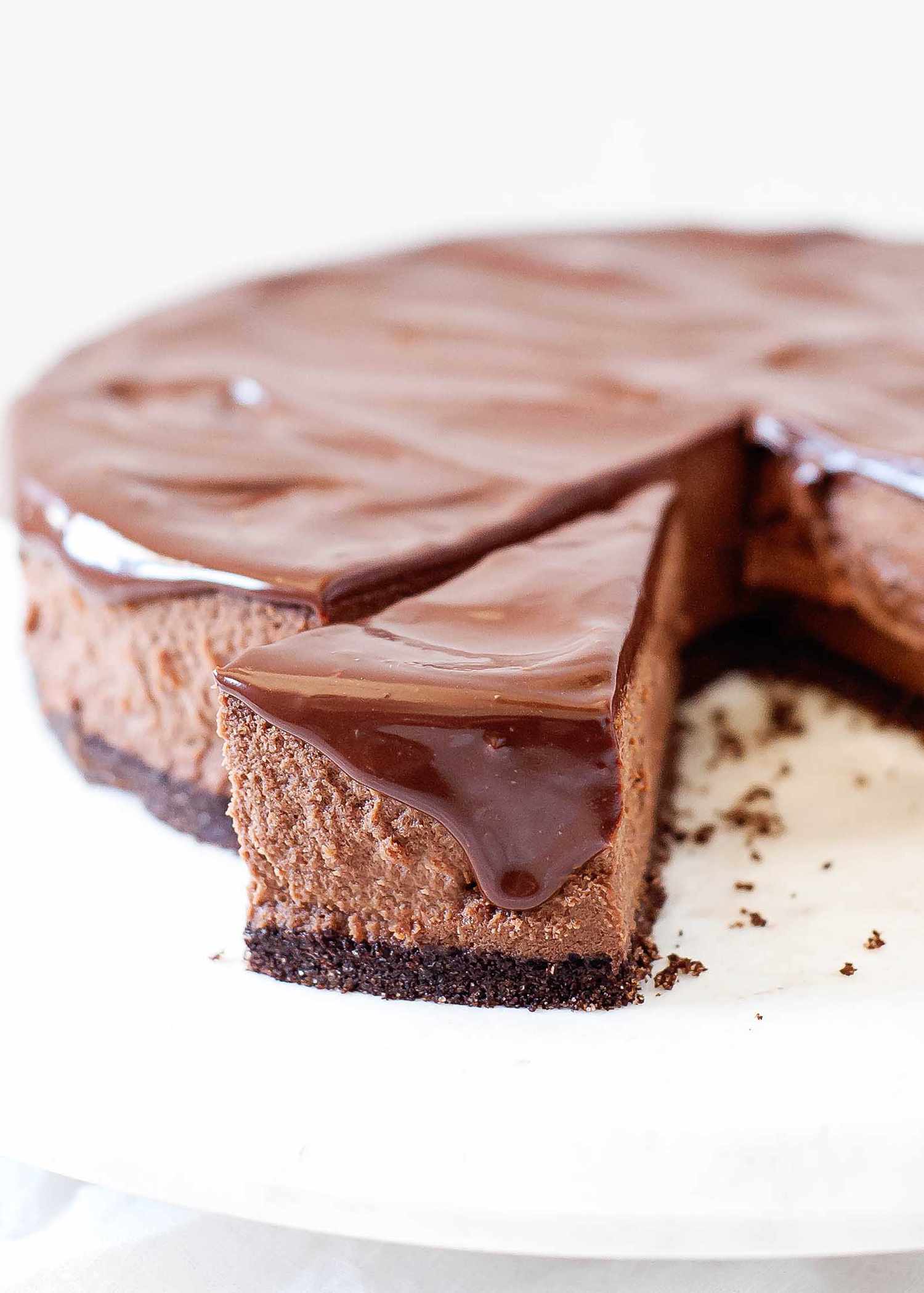 A slice of a chocolate cheesecake slightly removed from the rest of the cake.