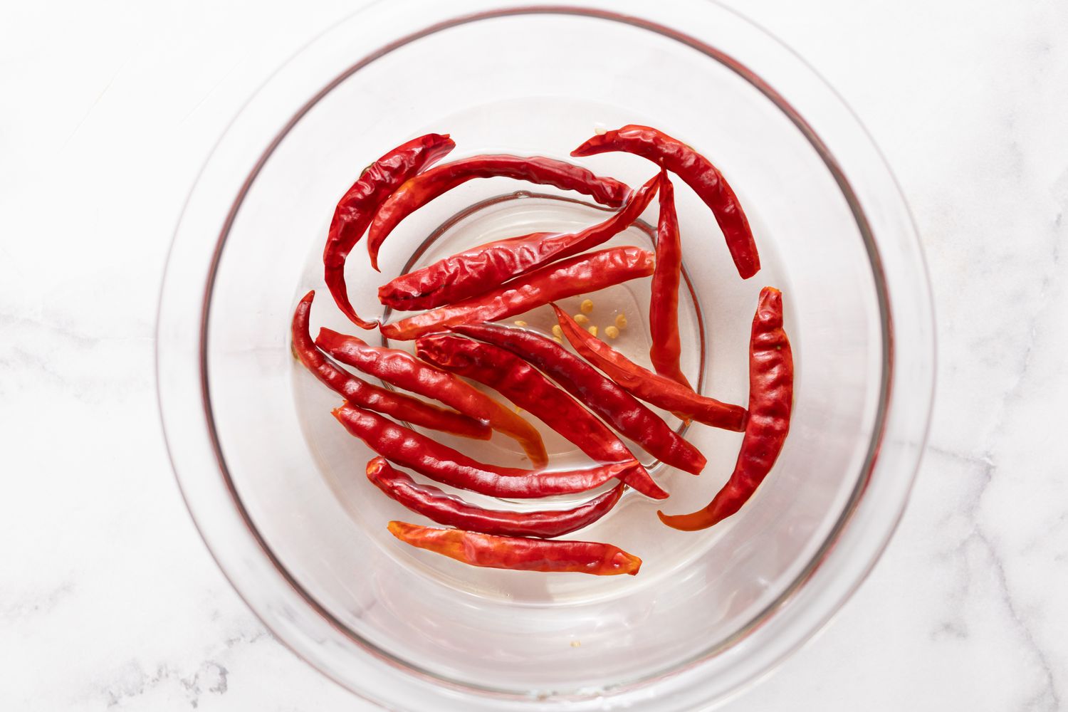 Peppers Floating in a Bowl of Water for Smoked Spatchcock Chicken with Harissa Butter and Grilled Carrots