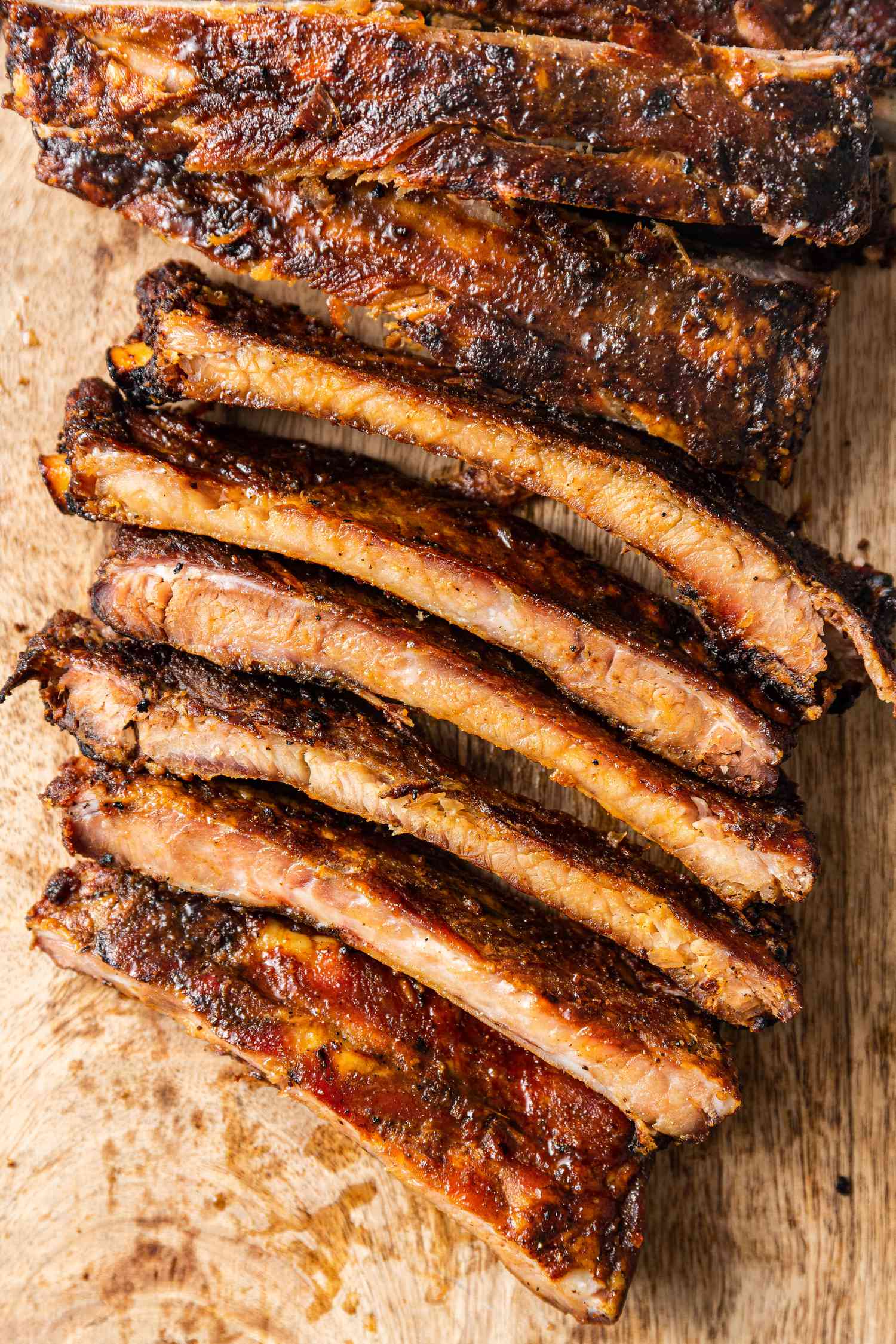 Memphis-Style Pork Ribs Cut into Piece on a Plank of Wood 