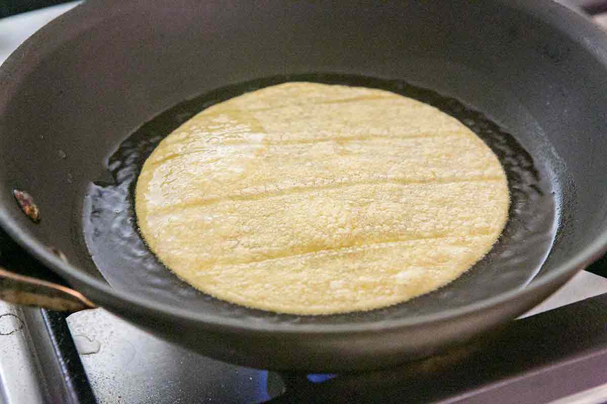 Softening tortillas in skillet for chicken enchiladas