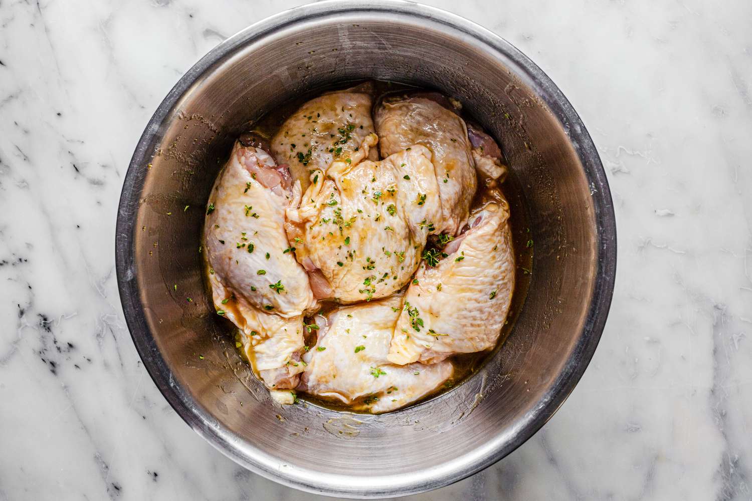 Chicken Thighs Marinating in a Bowl for Sheet Pan Recipe