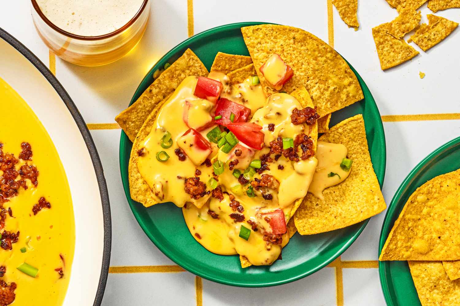 Plate of tortilla chips topped with chorizo queso tomatoes and garnishes