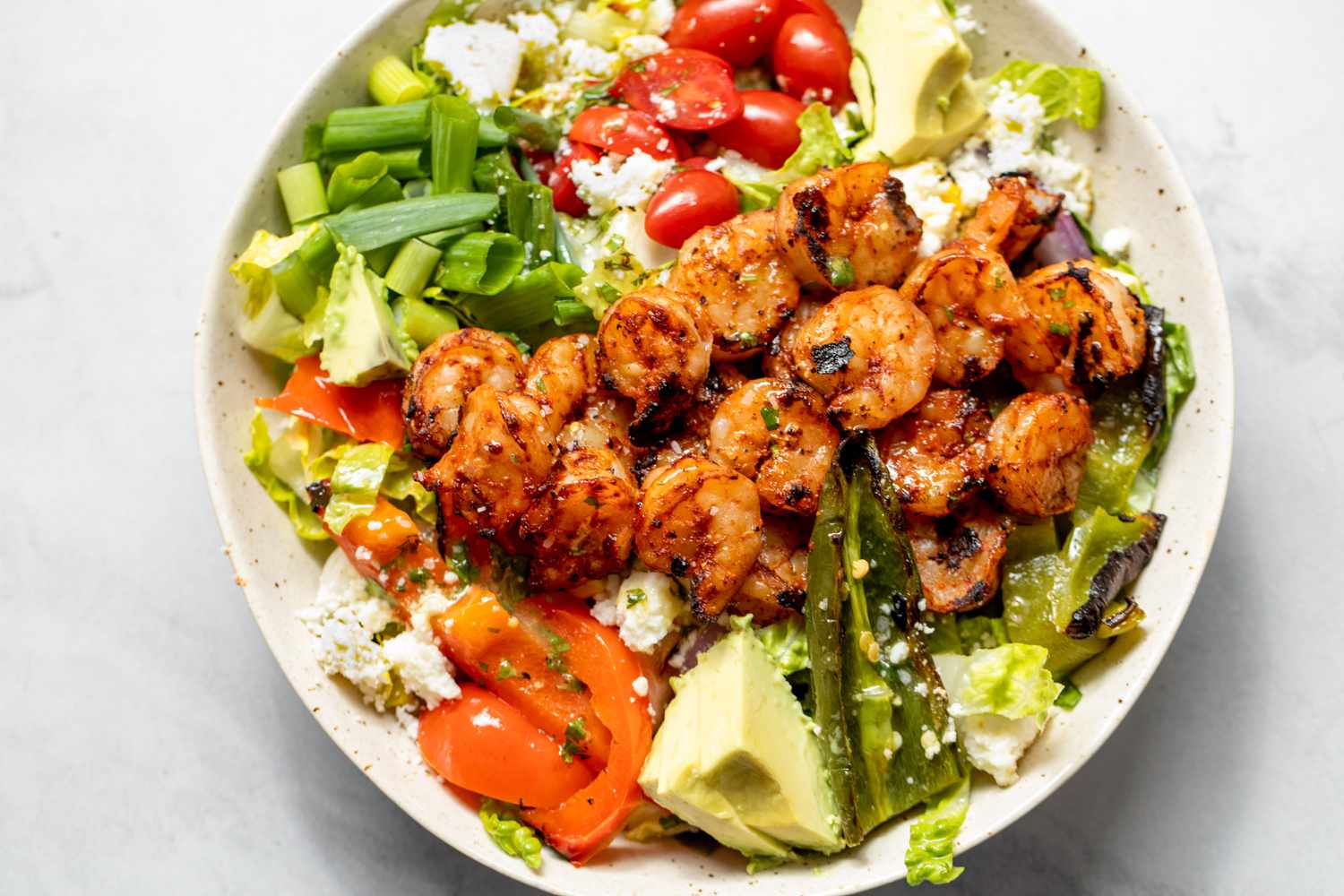Bowl of Grilled Shrimp Salad with Shrimp, Avocados, Cherry Tomatoes, and Cotija Cheese