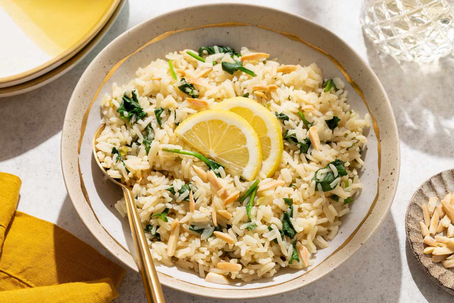 Side view of a plate with lemony spinach rice, topped with two lemon slices