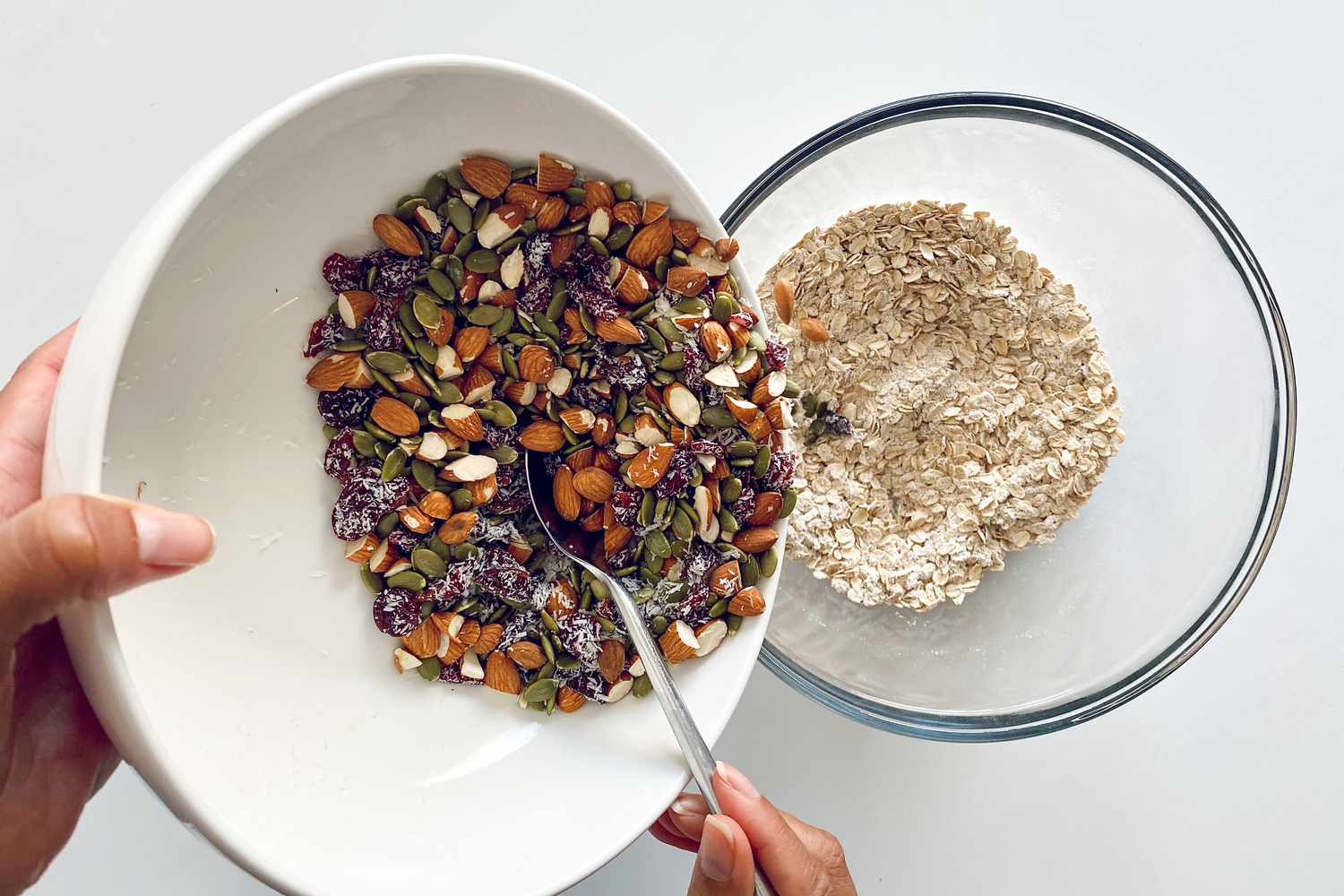 Pouring nuts and seeds into bowl with dry ingredients for Granola Bars.