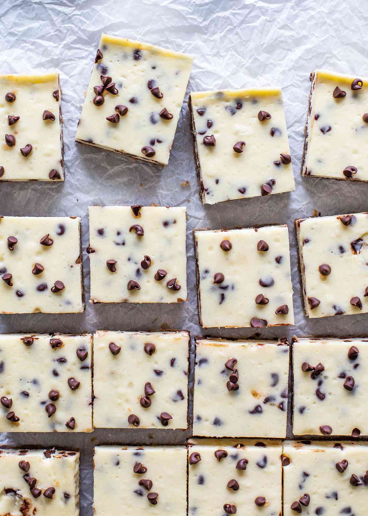 Chocolate chip cheesecake bars cut and laid out on parchment paper