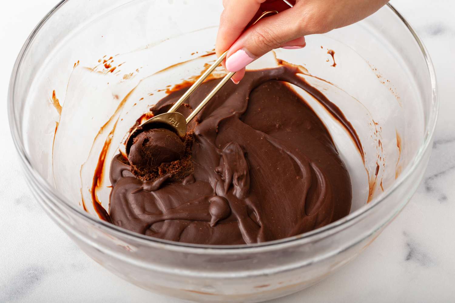 Rolling ganache in a ball using wooden skewers for a chocolate truffle recipe.