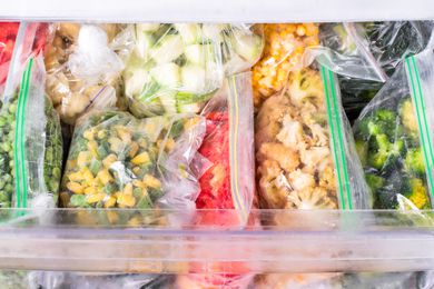 zip-top bags filled with frozen vegetables in a freezer 