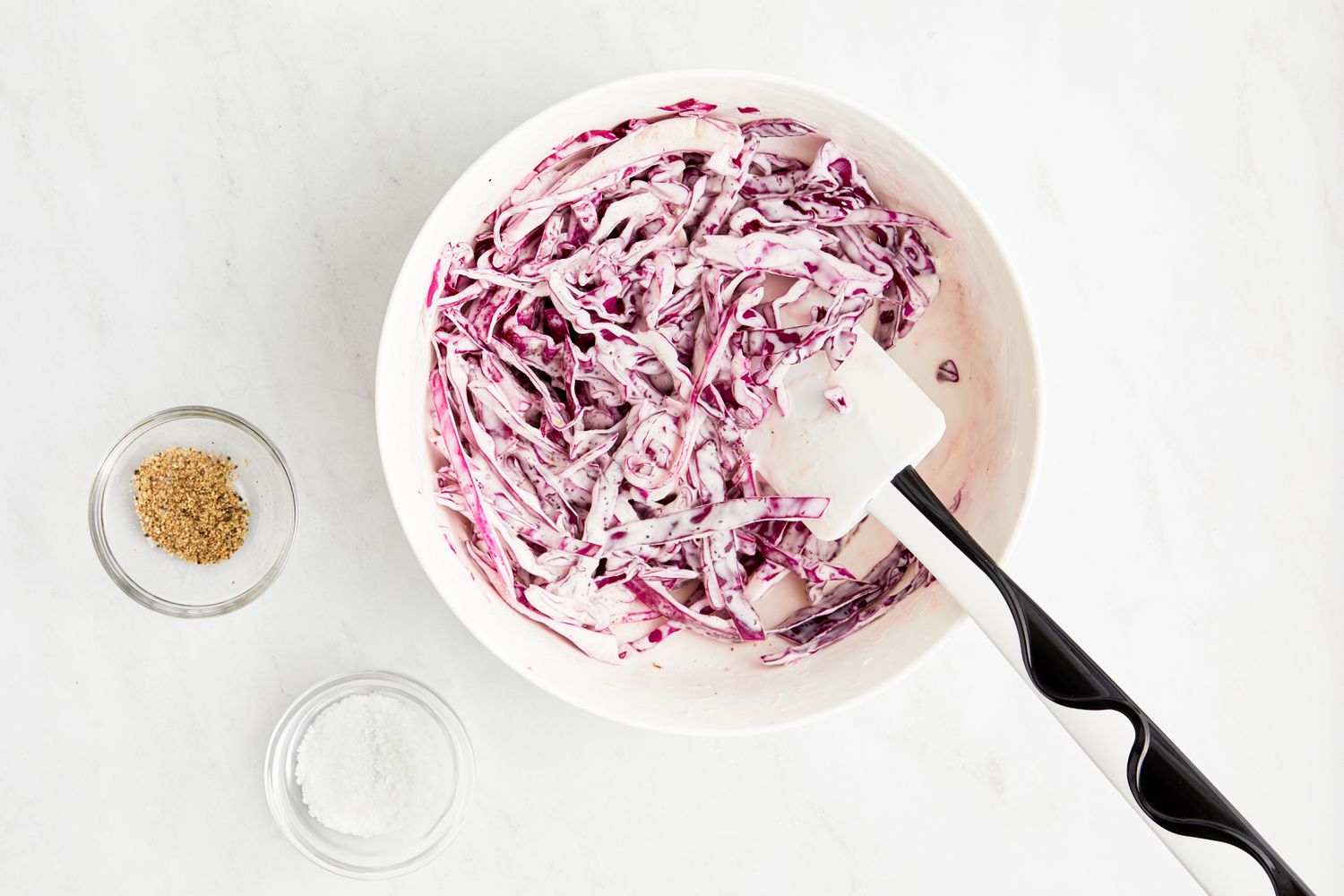 Bowl of Red Cabbage Slaw Next to a Small Bowl of Seasoning and Another Small Bowl of Salt for Blackened Shrimp Tacos Recipe