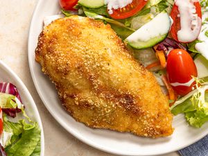 Overhead view of a plate with a ranch baked chicken breast and salad