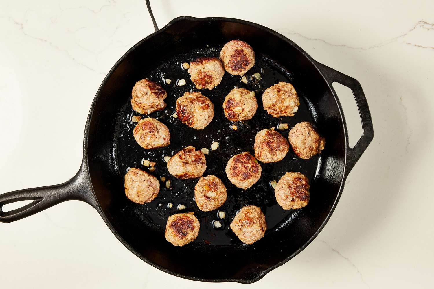 Copycat Ikea meatballs browned on a cast iron skillet