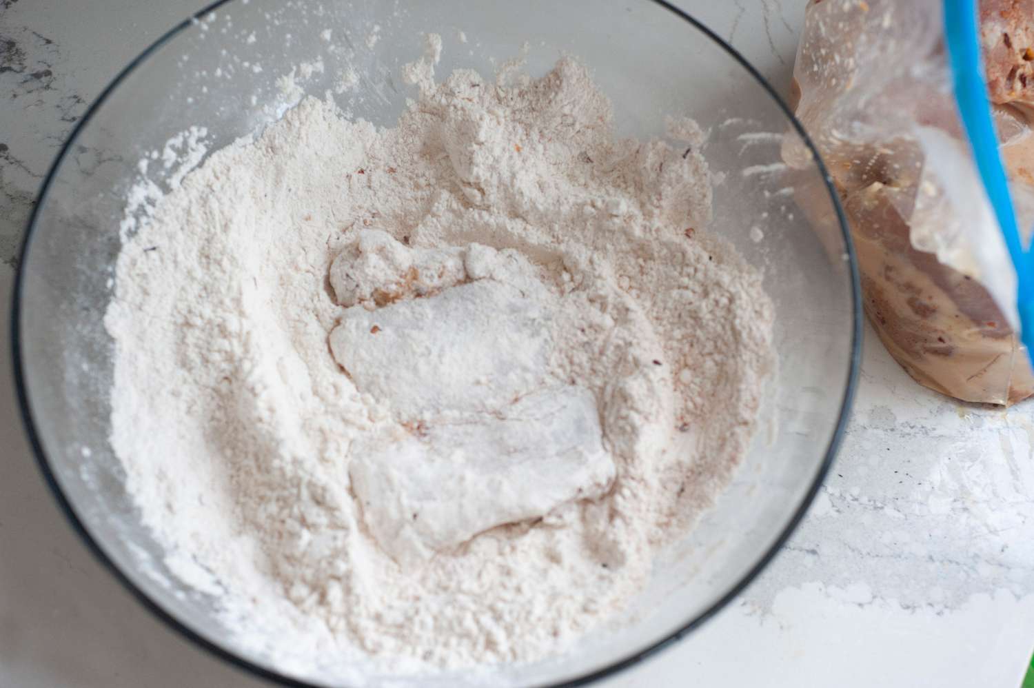 Chicken in breading mixture in a bowl
