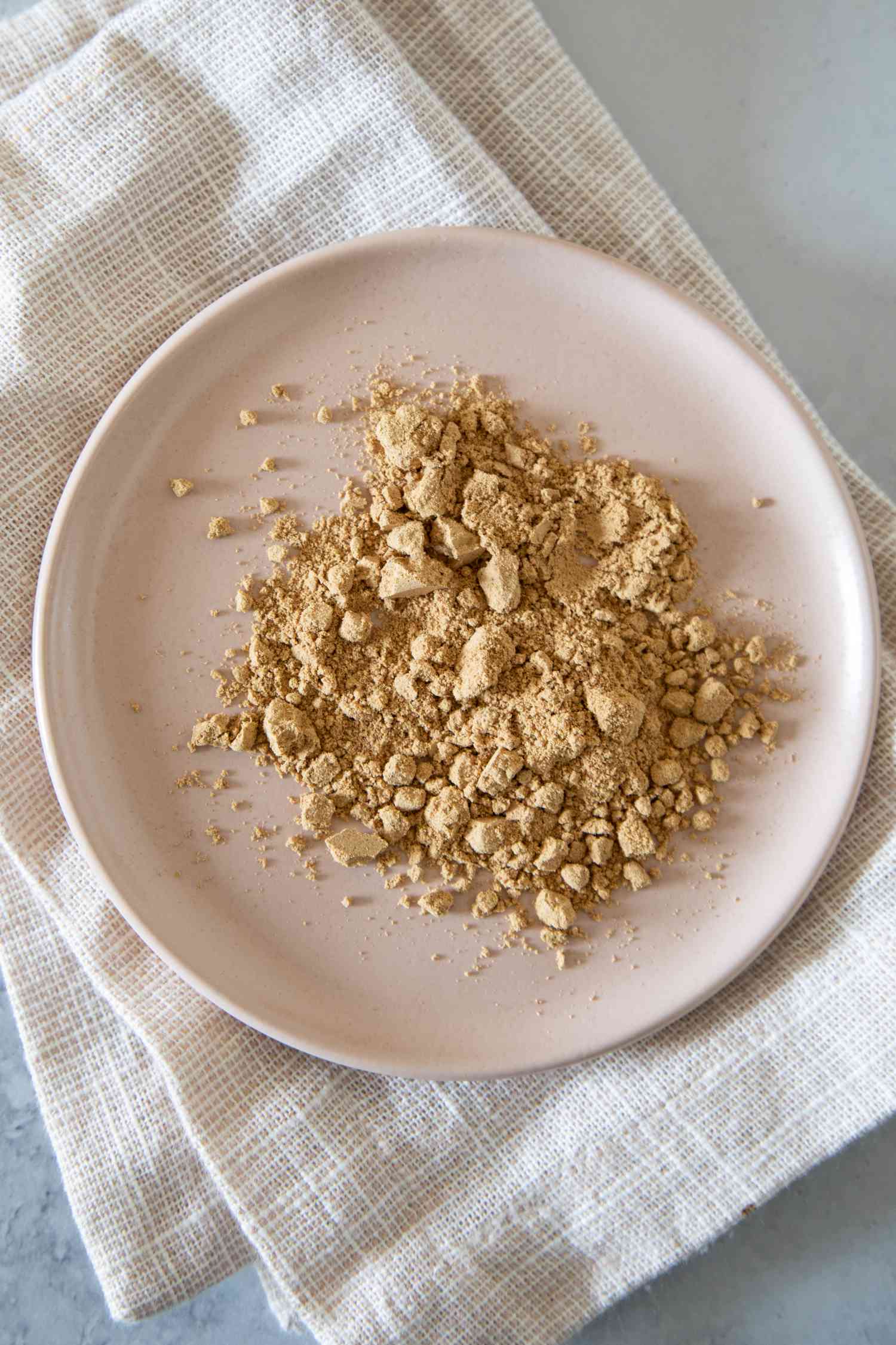 Ground ginger on a pink plate on a white cloth
