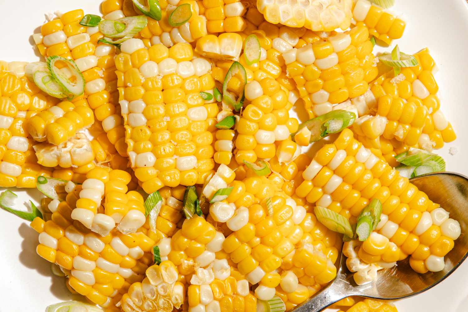 Cooked corn cut into pieces with sliced green onions