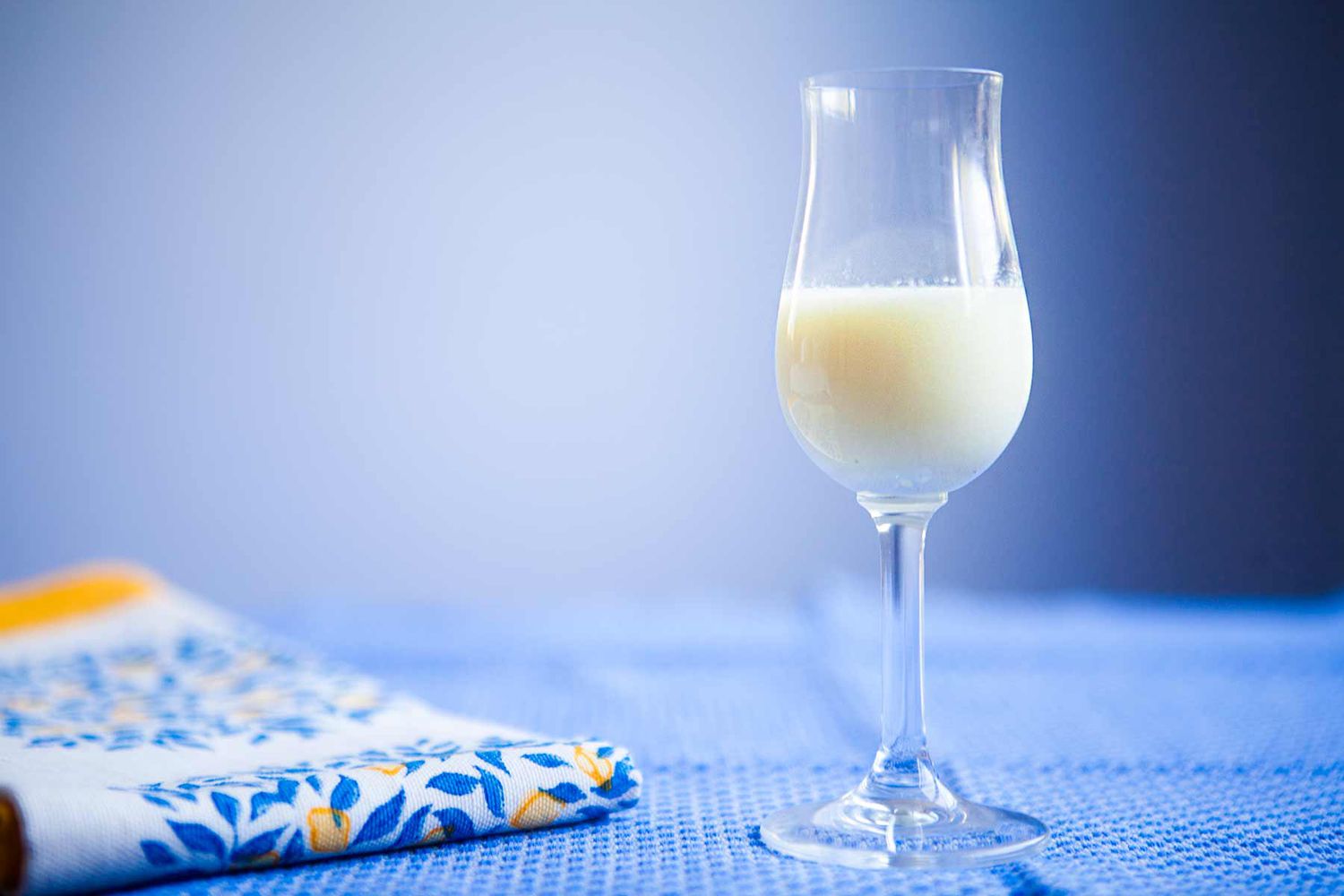 creme di limoncello in a tulip glass with a blue and yellow decorative cloth 