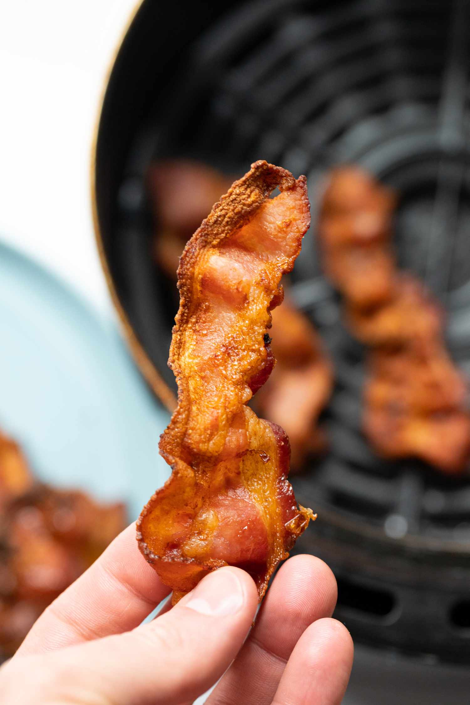 Hand Holding Air Fryer Bacon 
