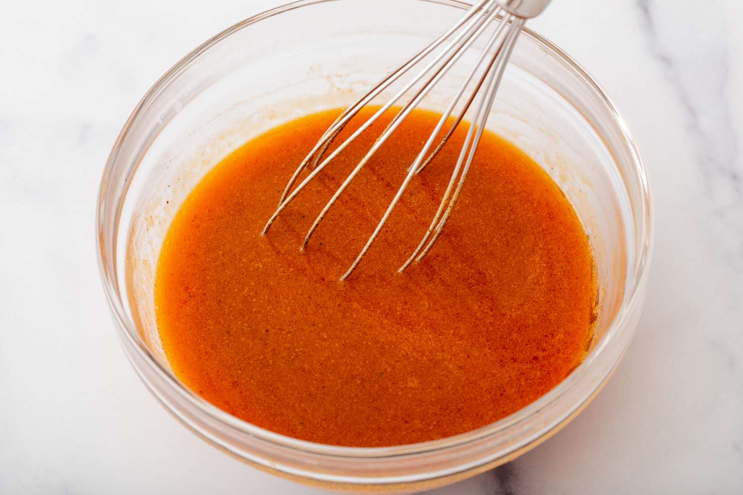 Whisking bbq sauce for a grilled chicken wings recipe.