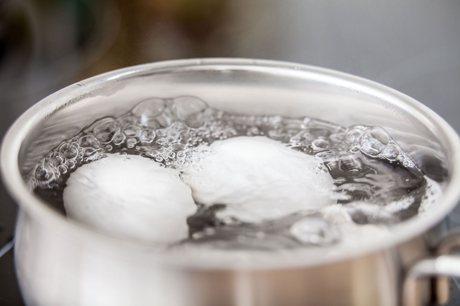 small pot of boiling water with eggs
