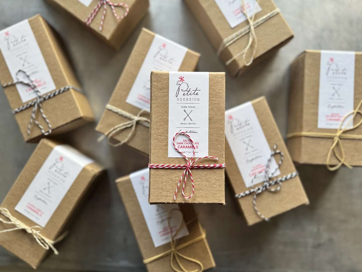 A group of brown gift boxes tied with string and tags arranged on a surface