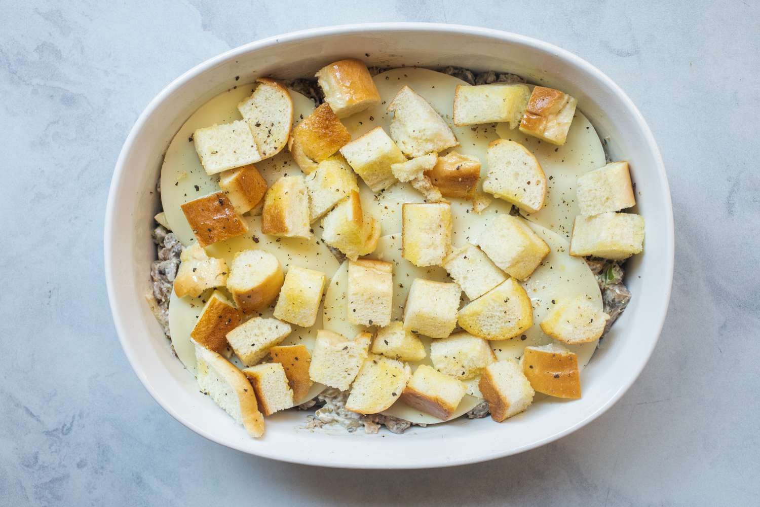 Unbaked assembled Philly cheesesteak casserole.