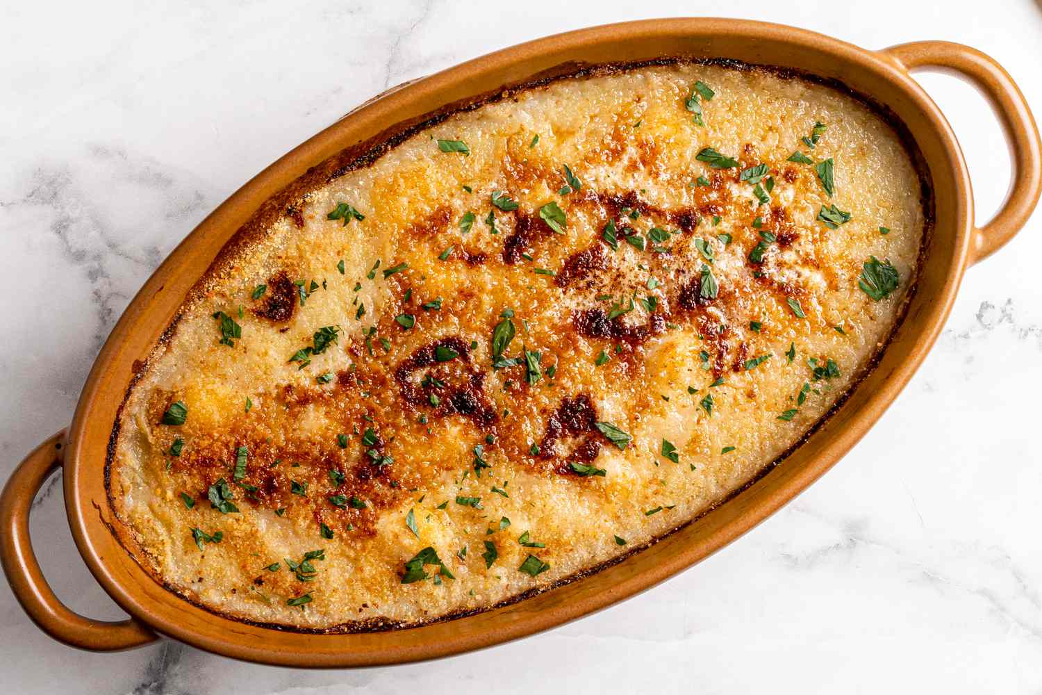 Golden brown baked breadcrumb topping over a dish or baked scallops from the oven