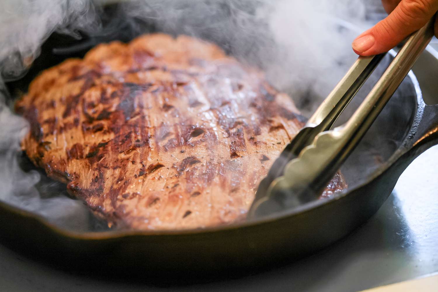 Showing how to cook flank steak in a cast iron skillet.