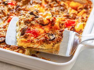 Sausage Breakfast Casserole Lifted from a Casserole Dish Using a Spatula