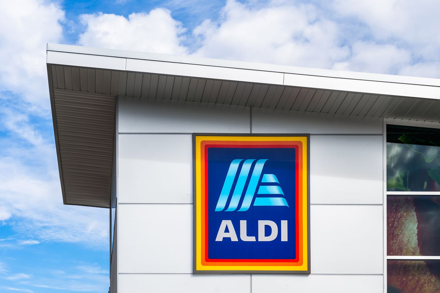 Aldi sign on an Aldi store with clouds and blue sky overhead