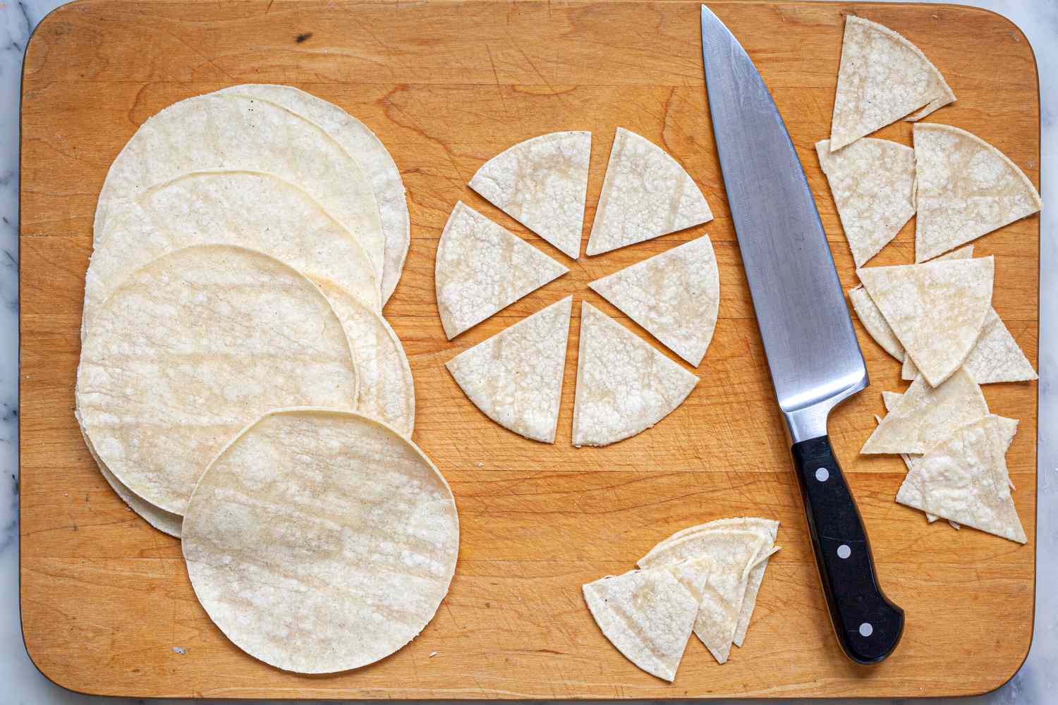 Cutting tortillas into wedges to make homemade tortilla chips.