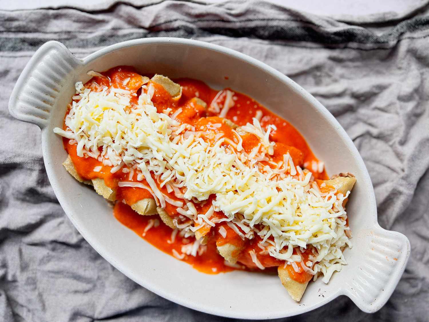 Pulled Pork Enchiladas Topped with Sauce and Cheese (Uncooked)