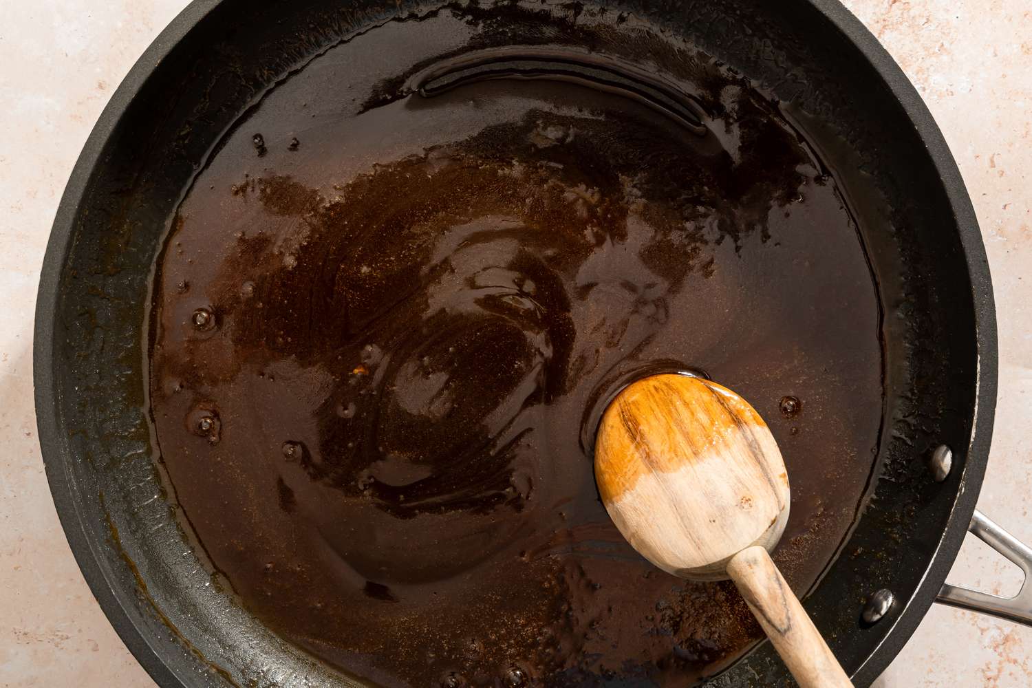 Saucepan containing melted sugar mixture with a wooden spoon