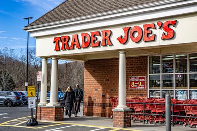 Trader Joe's storefront with shopping carts and pedestrians near the entrance