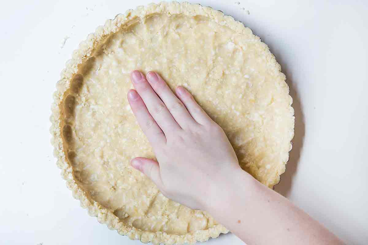Patting pastry dough in a tart pan