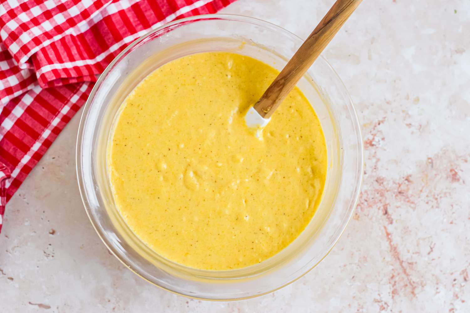 Corn Dog Muffin Batter Mixed Together in a Bowl Using a Rubber Spatula