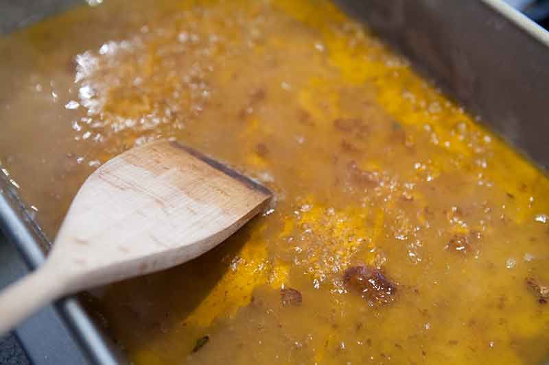 scraping drippings to make pan sauce for pork roast