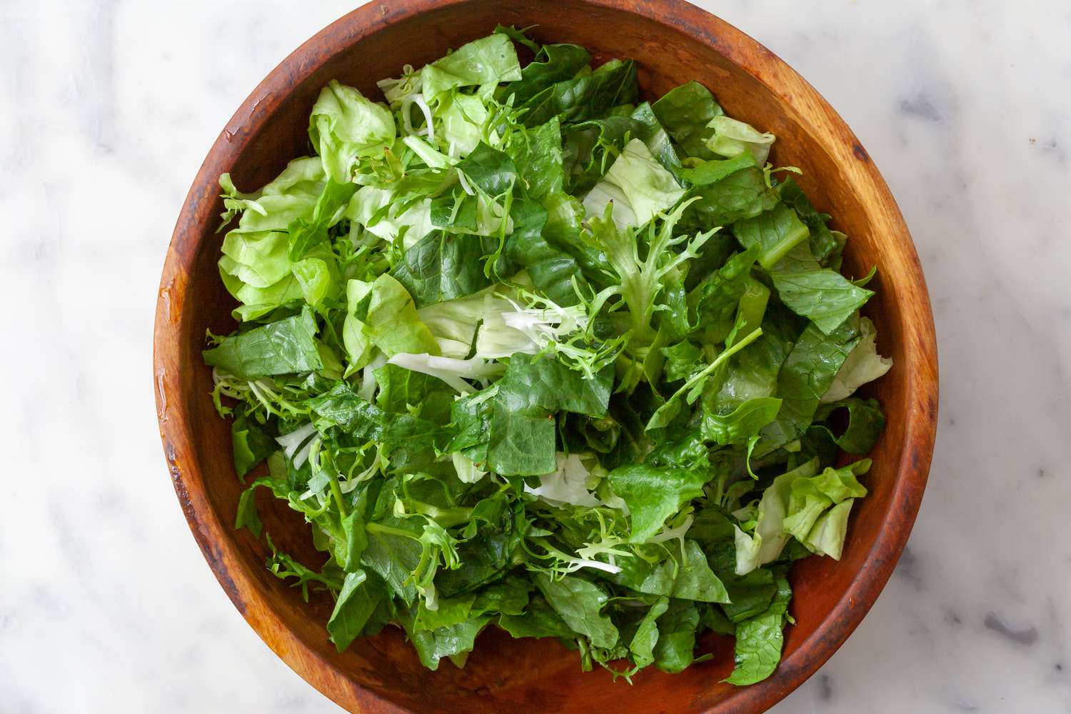 Chopped romaine lettuce in a wooden bowl for a cobb salad.