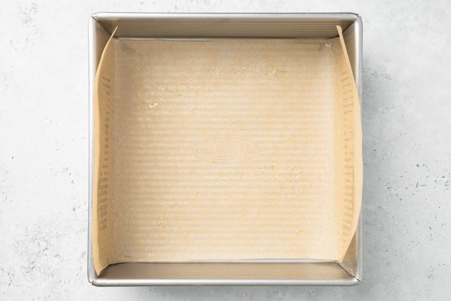 An 8x8 Baking Pan Lined With Parchment Paper for Flapjacks Recipe