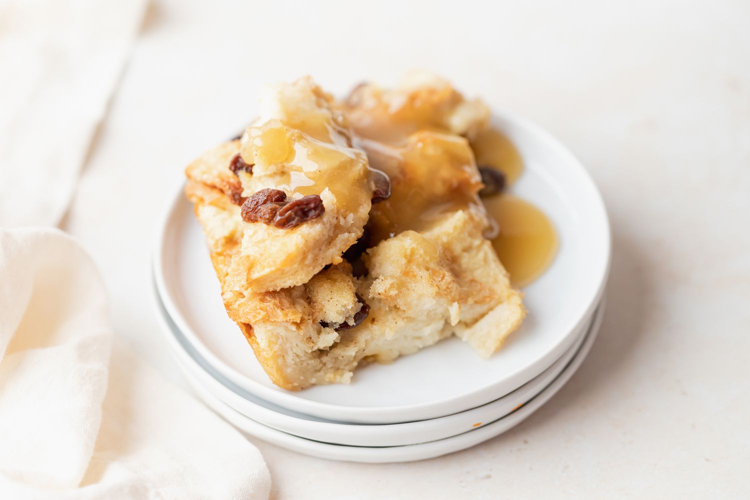 A large cut of easy bread pudding resting on a stack of plates