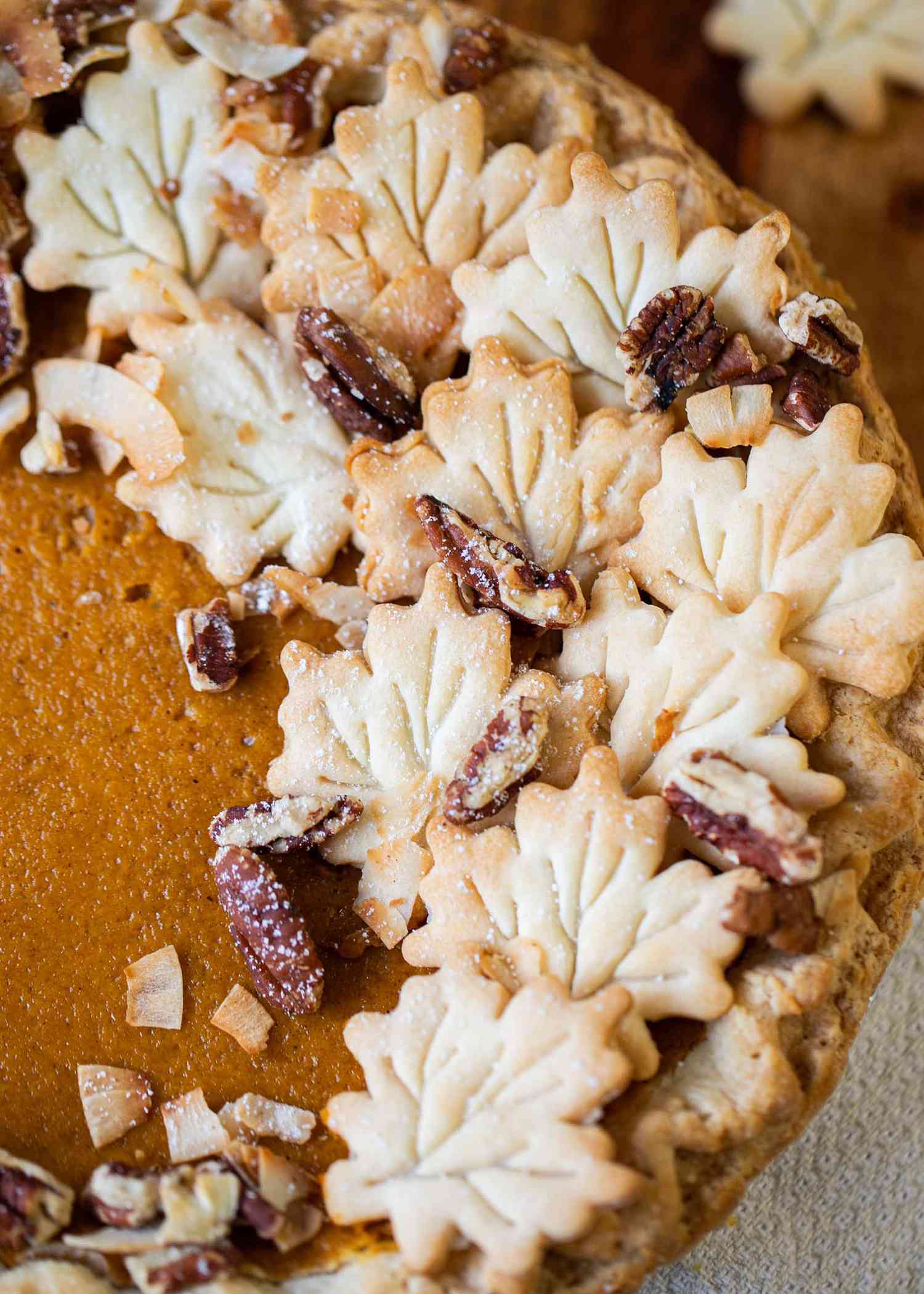 Leaves and pecans decorate the side of a pie for Thanksgiving family ideas.