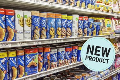 Shelves stocked with various brands and flavors of refrigerated dough products including crescent rolls and biscuits