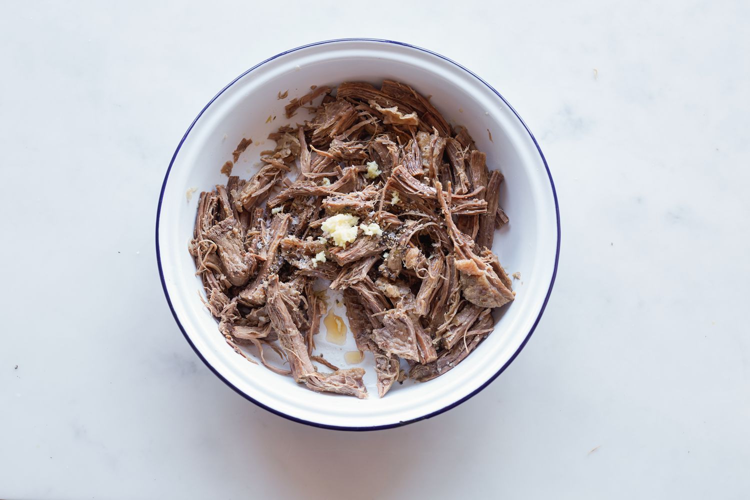 Adding seasoning to beef to make rice cake soup.